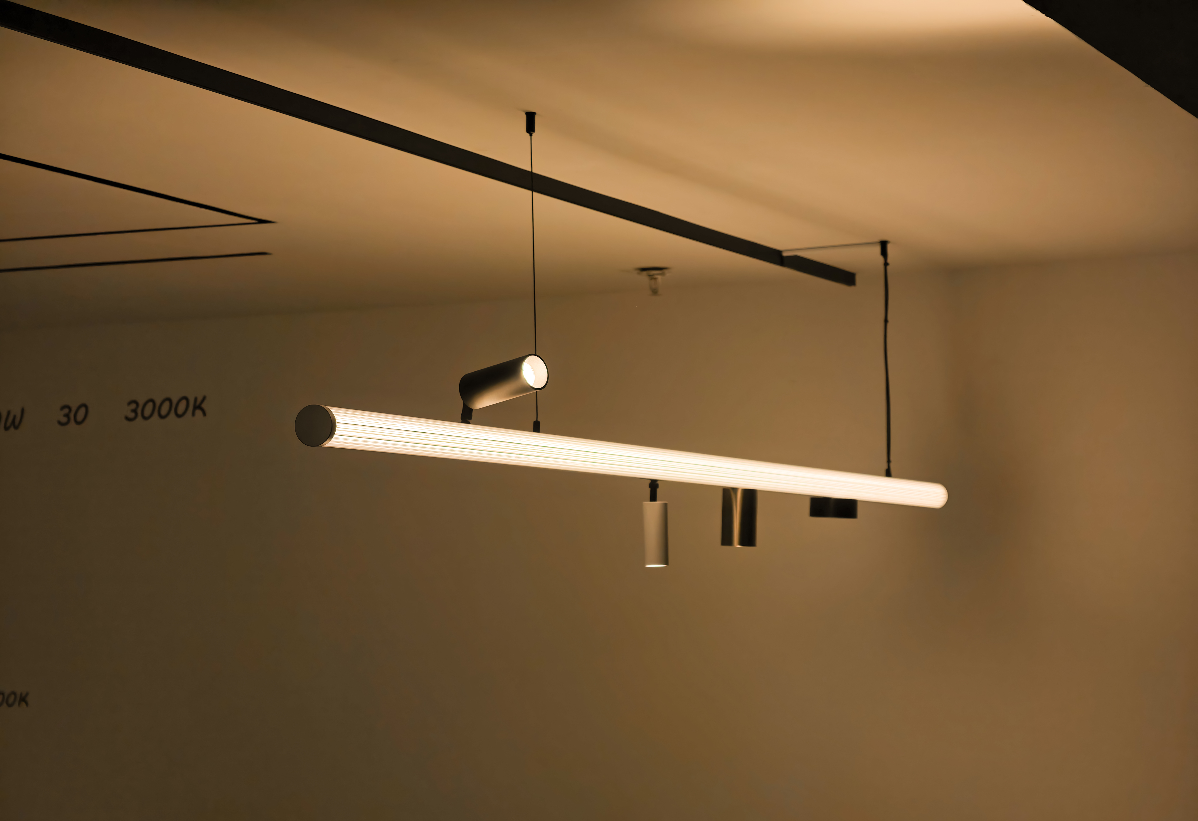 Bespoke lighting solutions in Dubai — a living room with linear pendants, cove and niche lighting